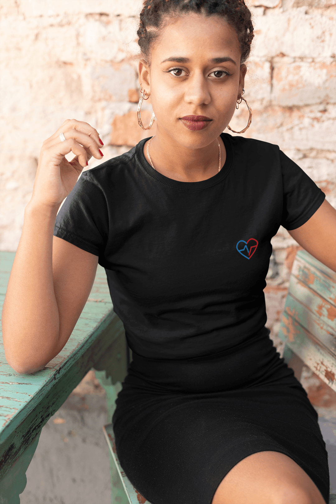 Beautiful woman in hoop earrings  sitting down wearing Love Clan Classic Embroidered T-Shirt by Norian Love