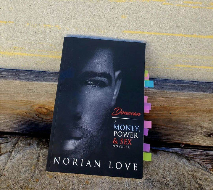 Donovan: A Money, Power & Sex Story - Norian Love against a wall with tabs inside the book