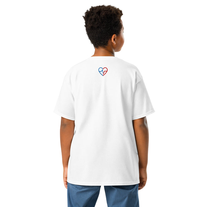 Kid wearing a white God Made t-shirt with a colorful heart design on the back, standing against a white background.
