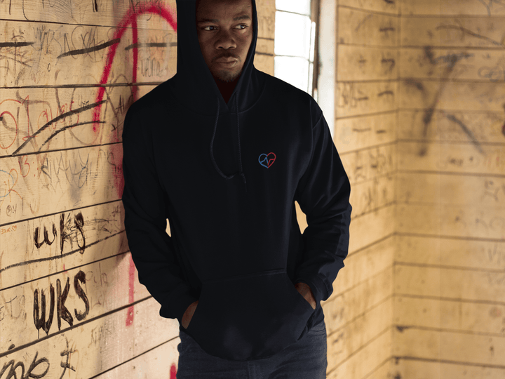 Man leaning against the wall thinking while wearing Love Clan Classic Embroidered Hoodie by Norian Love