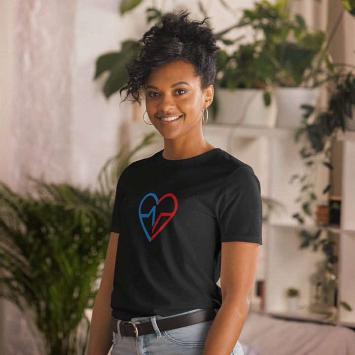 Black woman smiling inside of a home wearing the Love Clan Signature Tee