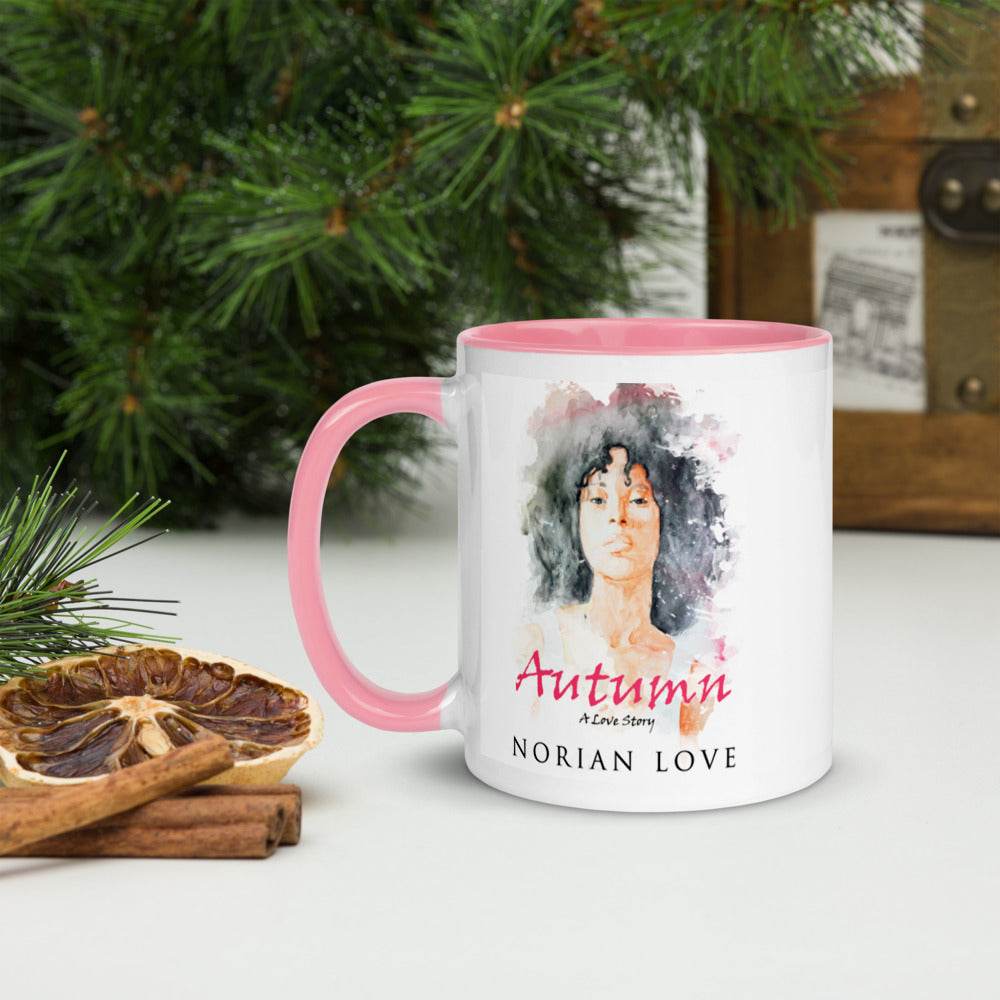 Autumn mug with pink interior displayed on a table with pine greenery and cinnamon sticks.