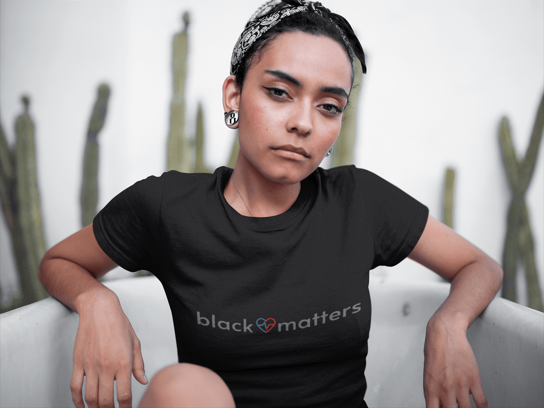 Black woman relaxing in a bathtub while wearing a Black Love Matters shirt