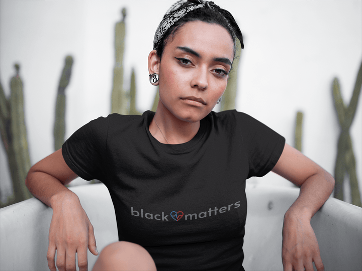 Black woman relaxing in a bathtub while wearing a Black Love Matters shirt