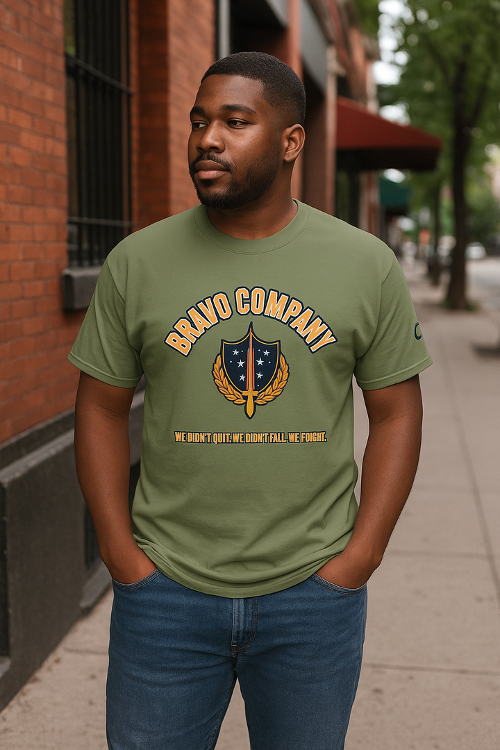 Black man wearing a military green Bravo Company shirt on a city street
