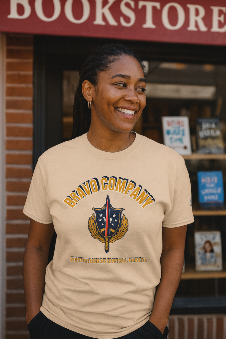 Black woman wearing a sand-colored Bravo Company shirt standing outside a bookstore laughing