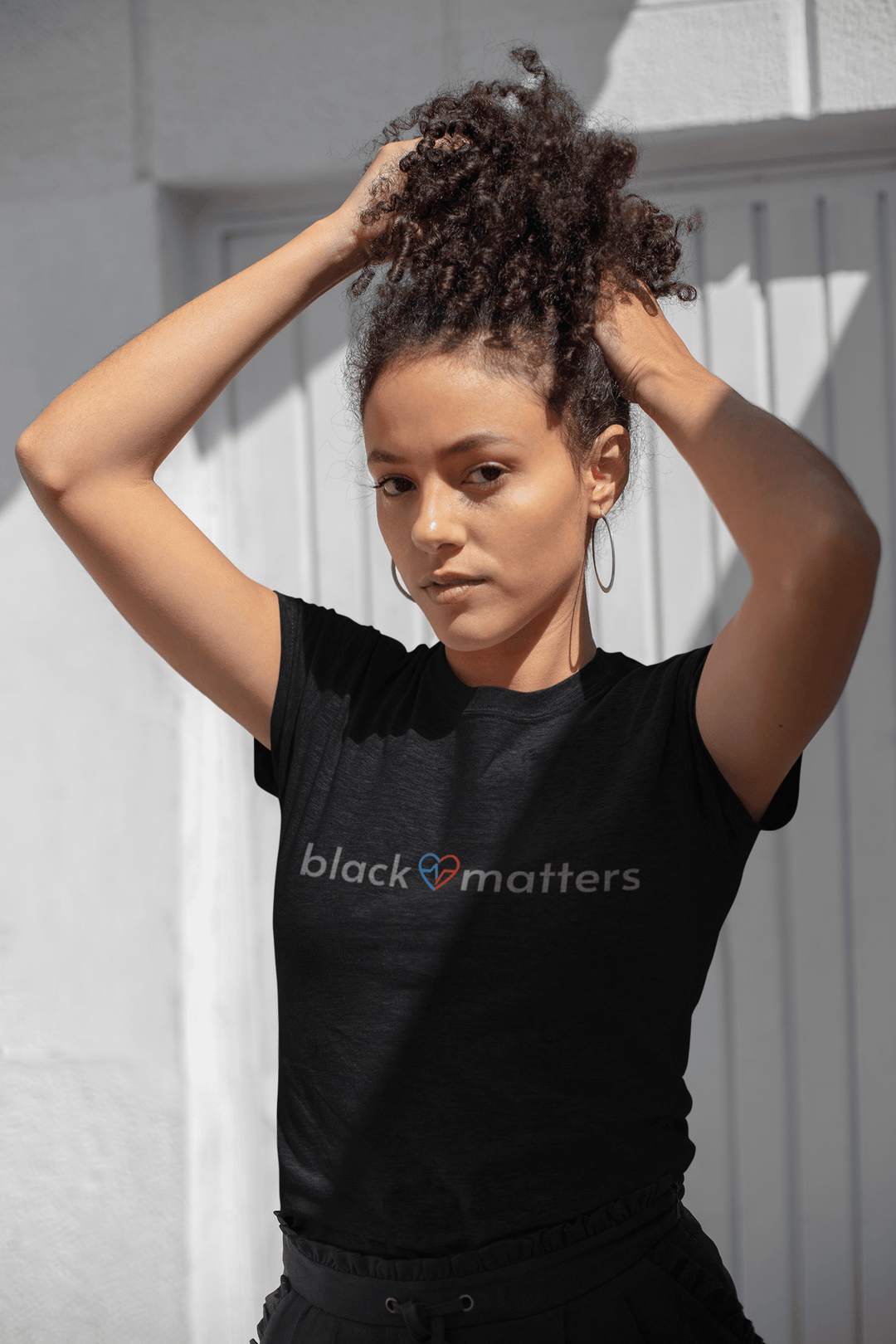 Black woman posing in a Black Love Matters shirt on a city street
