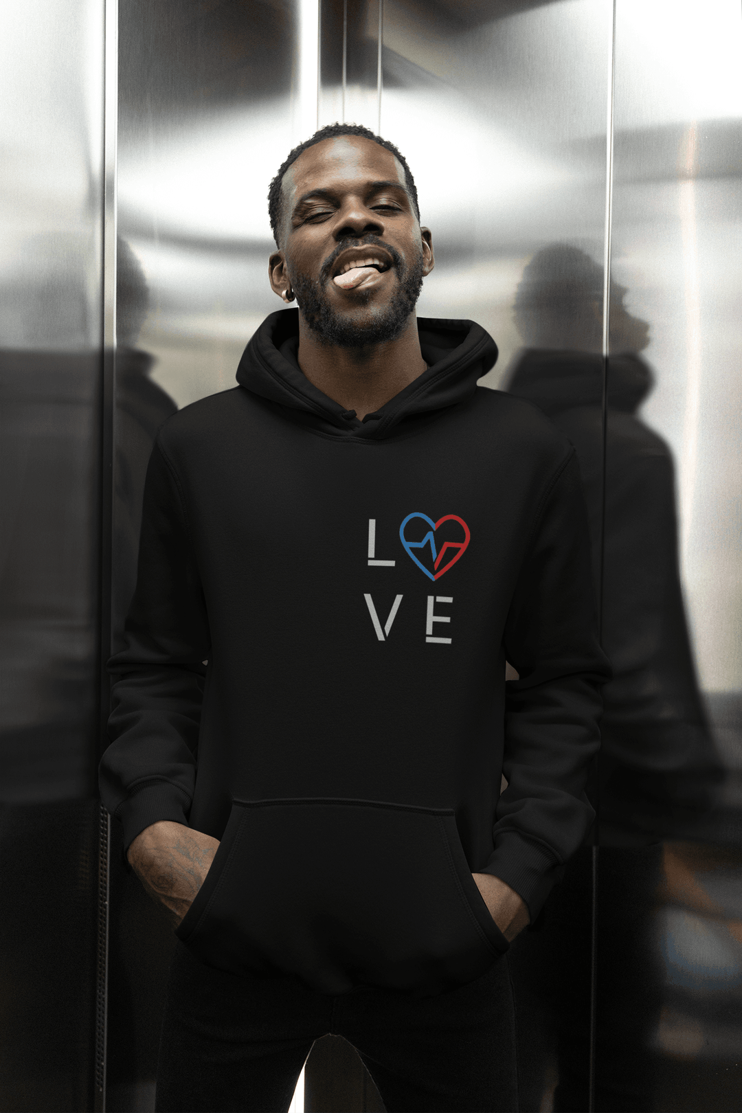 Black man wearing the black Love Season Hoodie with the red and blue Love Clan emblem, posing in an elevator in a modern streetwear setting.