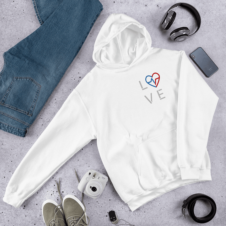 Black-owned streetwear white Love Season Hoodie with red and blue Love Clan emblem displayed in a flat lay with jeans, shoes, camera, and headphones.