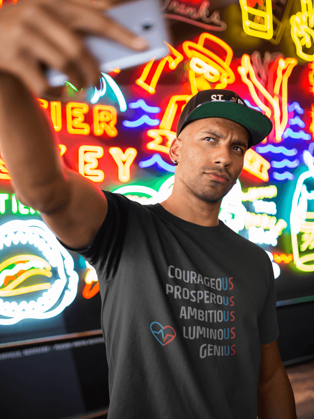 Man wearing The US Tee taking a selfie in front of bright neon signs