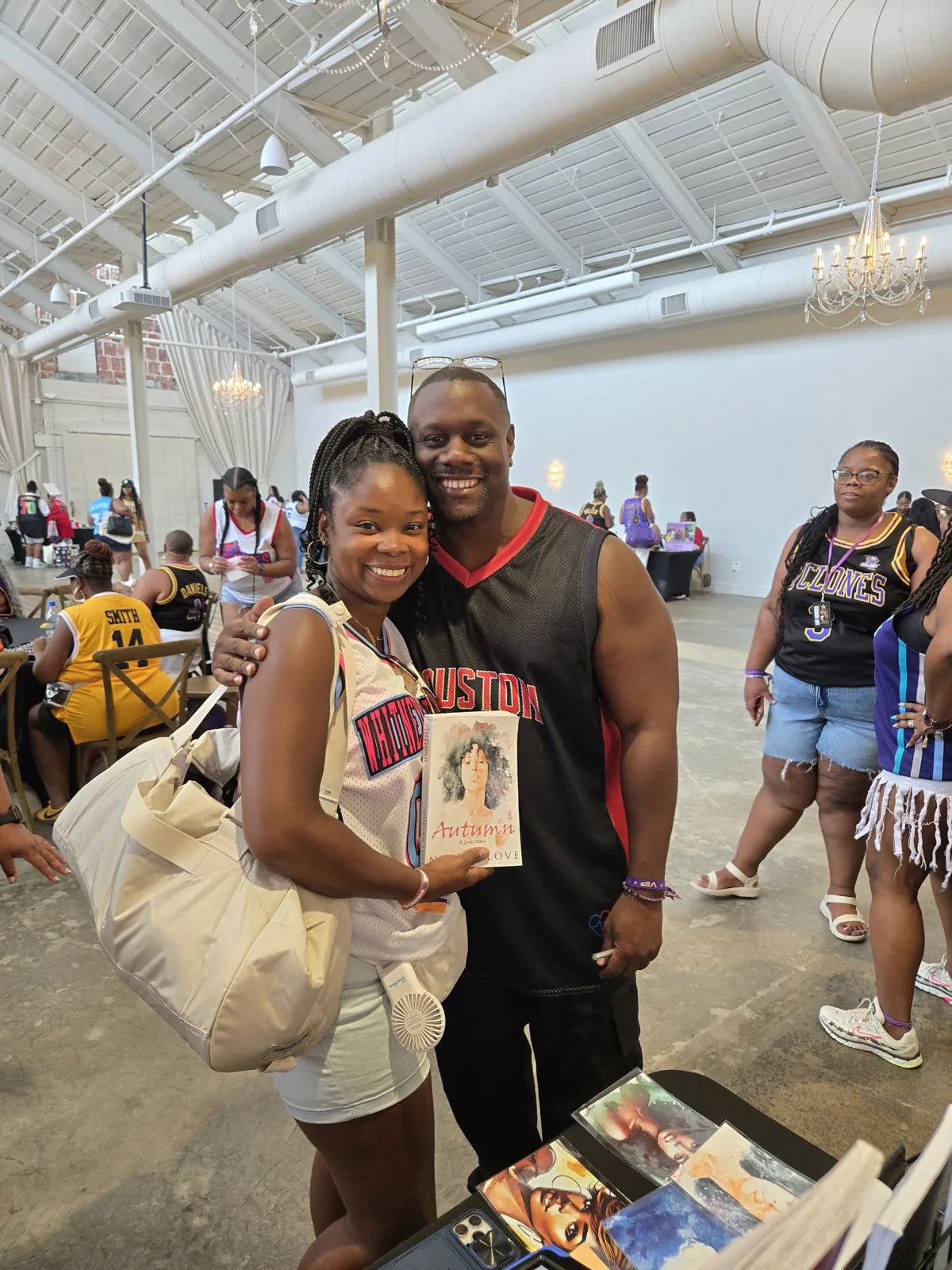 Norian Love beside a smiling reader holding Autumn: A Love Story.